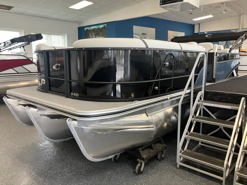 Slide: The Image of 2025 Crest 240 SLC Classic LX pontoon boat in showroom with sleek black design. - 3