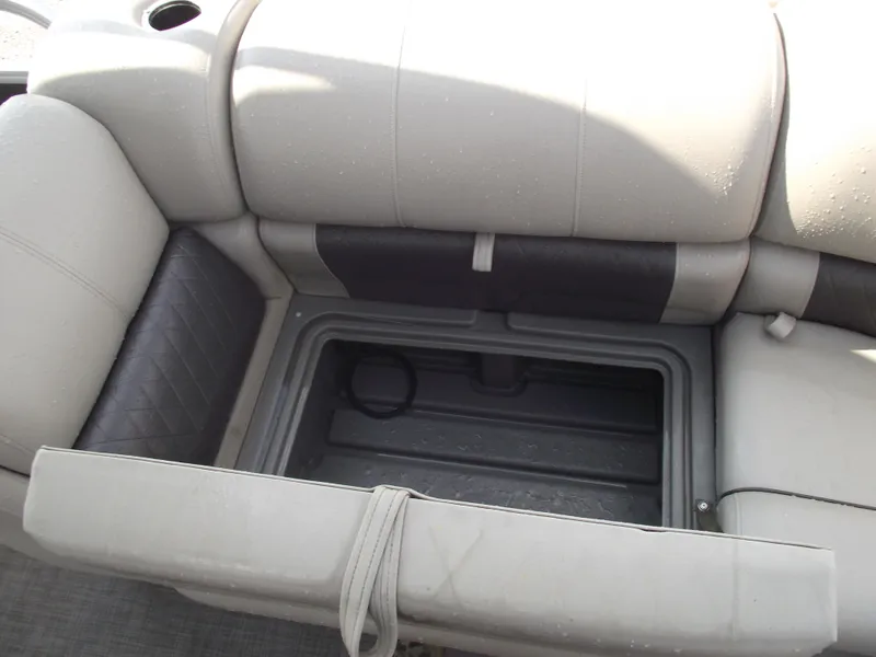 Slide: The Image of Sun Tracker Party Barge 20 DLX 2023, open storage compartment under cushioned seat. - 10