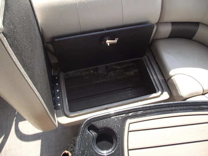 Slide: The Image of 2023 Sun Tracker Party Barge 20 DLX storage compartment with open seat and cup holder. - 27