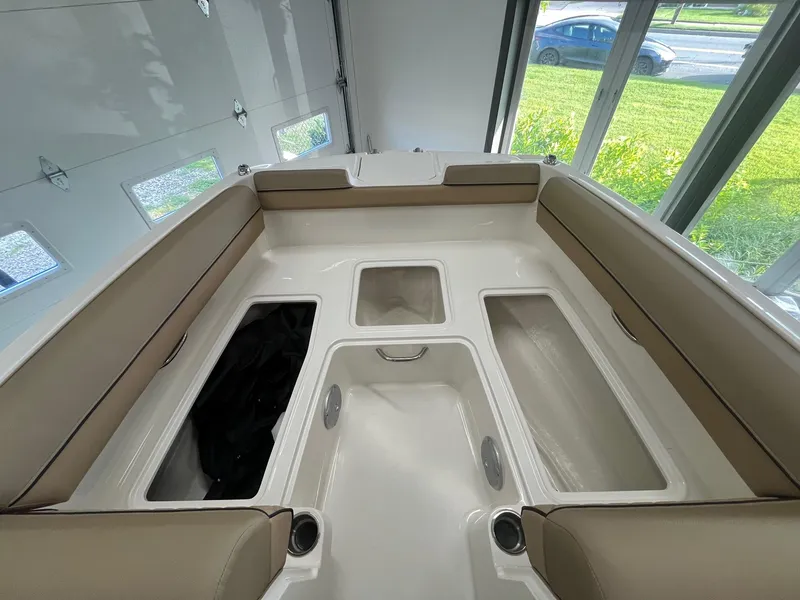 Slide: The Image of 2025 Bayliner D20 boat interior with beige seating and storage compartments. - 12