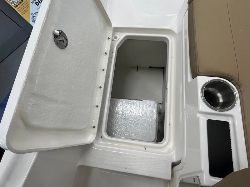 Slide: The Image of Open storage compartment on 2025 Bayliner D20 boat with cup holder and seat. - 20
