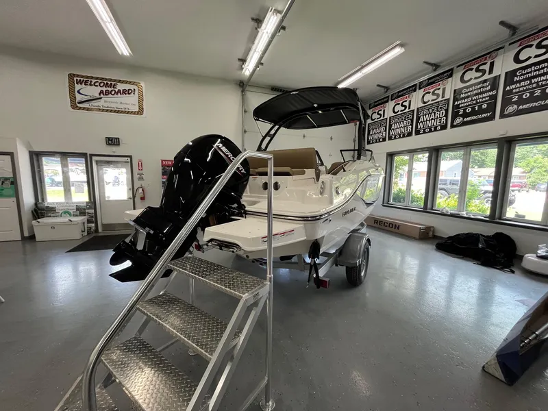 Slide: The Image of 2025 Bayliner D20 boat displayed indoors with a powerful outboard motor. - 3