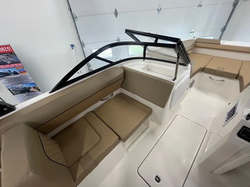 Slide: The Image of 2025 Bayliner D20 boat interior with beige seating and sleek design in a showroom. - 9