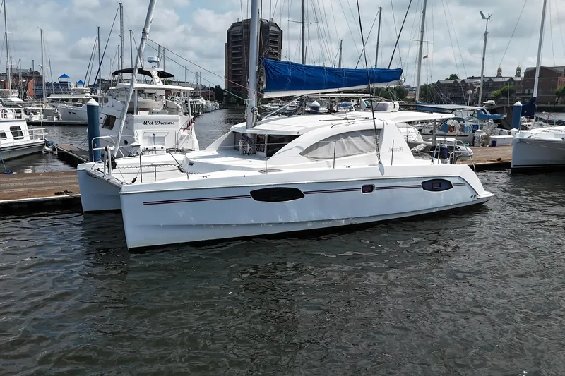 The Image of 2012 Leopard 39 Owner's Version catamaran docked in a marina, featuring sleek design and blue sail. - 0