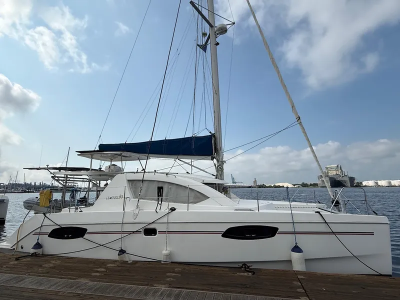 Slide: The Image of 2012 Leopard 39 Owner's Version catamaran docked at a marina under a clear sky. - 3