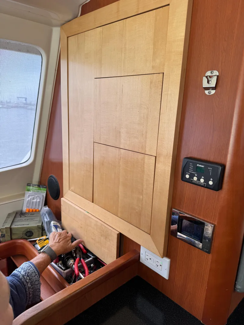 Slide: The Image of Interior of 2012 Leopard 39 yacht with wooden cabinetry and person accessing storage. - 37