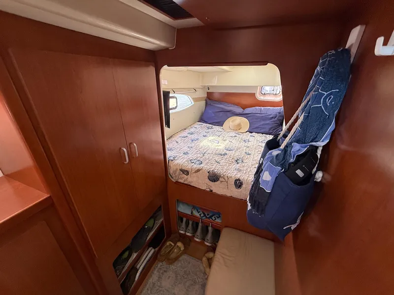 Slide: The Image of Cozy bedroom in 2012 Leopard 39 Owner's Version yacht with wooden cabinetry and nautical decor. - 46