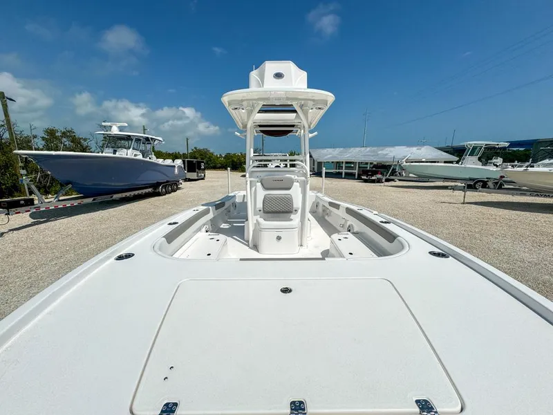 Slide: The Image of 2024 Caymas 28 HB boat on display in a sunny outdoor showroom. - 19