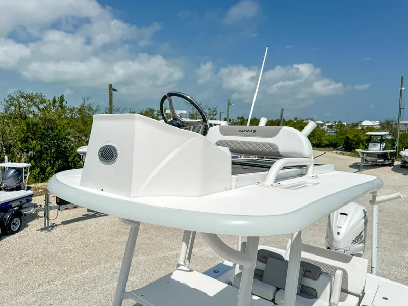 Slide: The Image of 2024 Caymas 28 HB boat helm station with steering wheel, set against a clear blue sky. - 20
