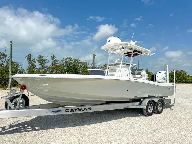 Slide: The Image of 2024 Caymas 28 HB boat on trailer, parked outdoors under a clear blue sky. - 3