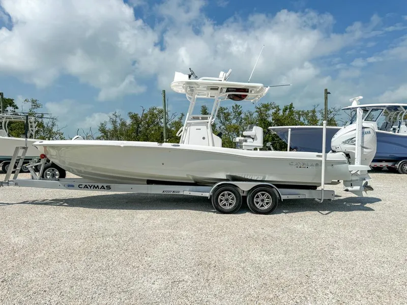 Slide: The Image of 2024 Caymas 28 HB boat on trailer, parked outdoors under a cloudy sky. - 4