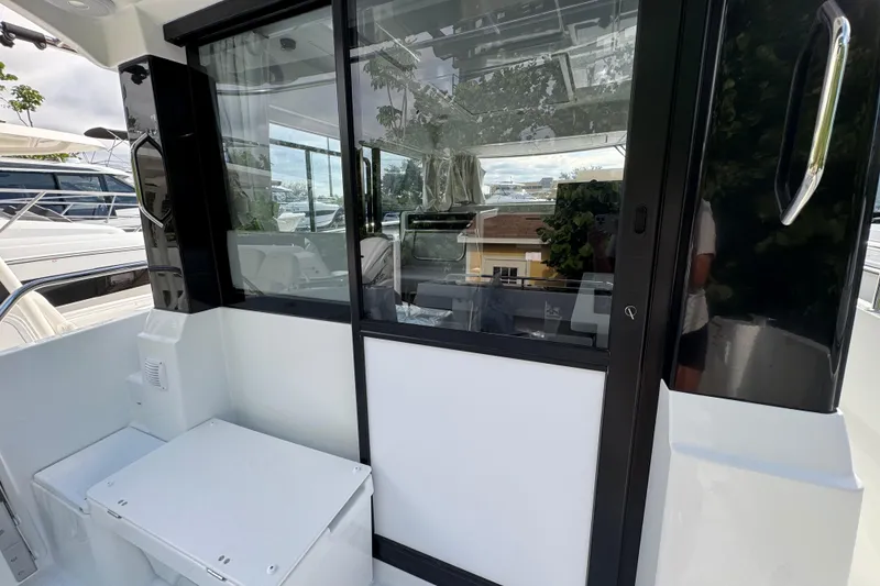 Slide: The Image of 2026 Jeanneau NC 895 Series 2 boat with sleek sliding glass door and modern interior. - 2