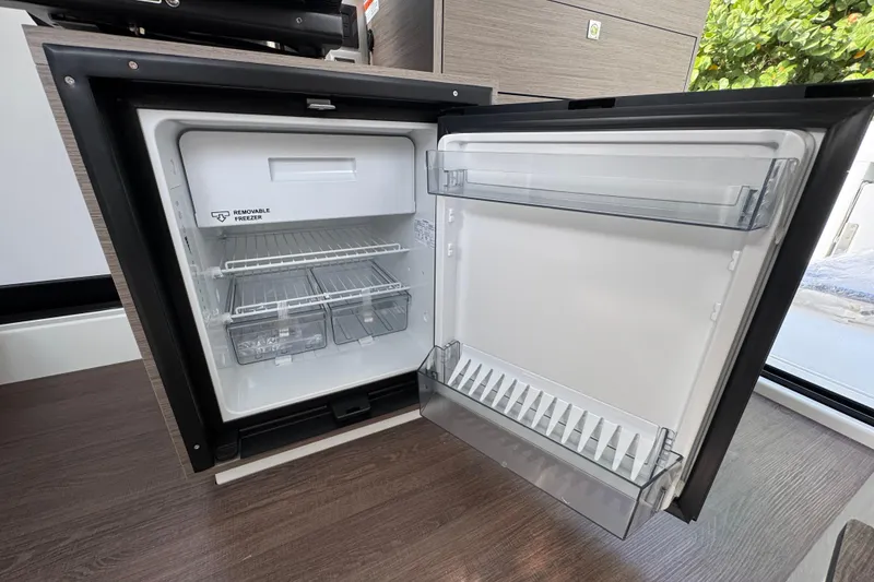 Slide: The Image of Open refrigerator in 2026 Jeanneau NC 895 Series 2 boat, featuring removable freezer compartment. - 6