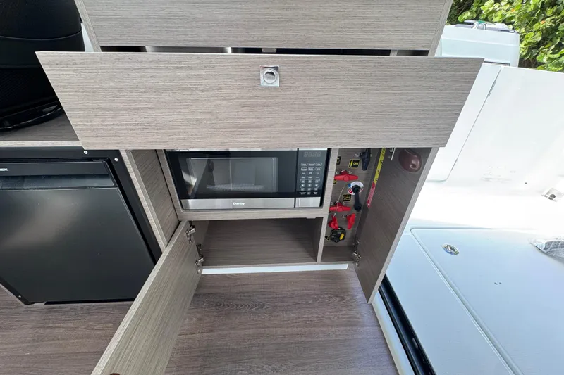 Slide: The Image of Interior of 2026 Jeanneau NC 895 Series 2 with microwave and storage cabinets. - 7