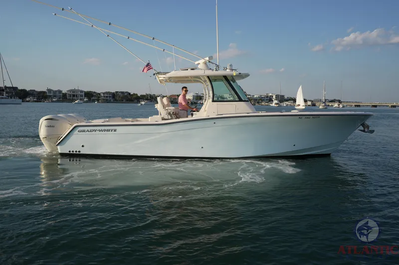 Slide: The Image of 2024 Grady-White Canyon 336 boat cruising on calm water, clear sky background. - 0