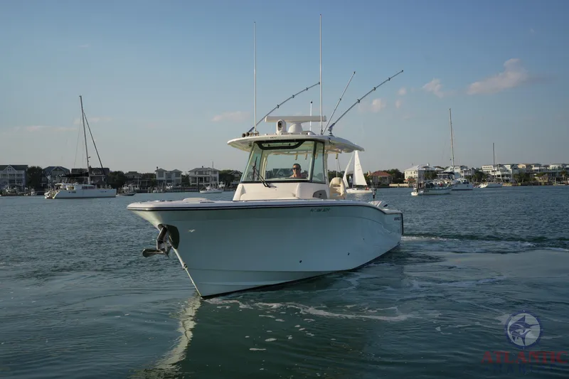 Slide: The Image of 2024 Grady-White Canyon 336 boat cruising in a scenic harbor setting. - 10