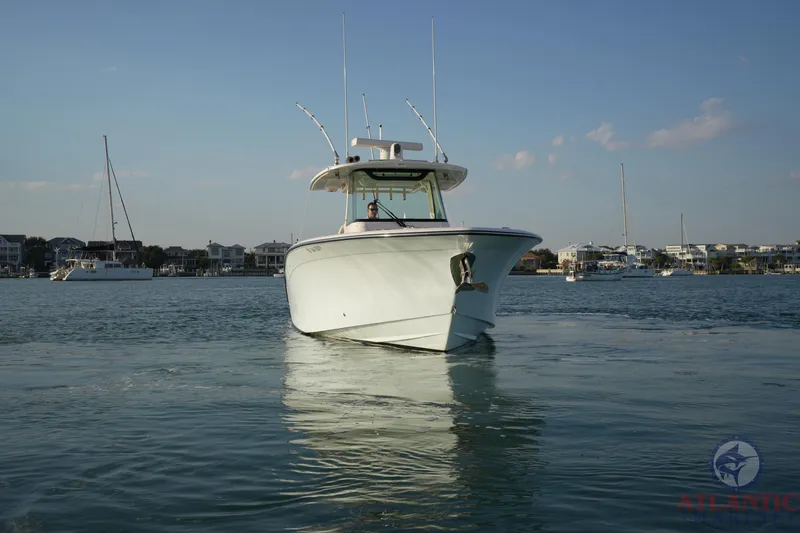 Slide: The Image of 2024 Grady-White Canyon 336 boat on calm water, with coastal background. - 11