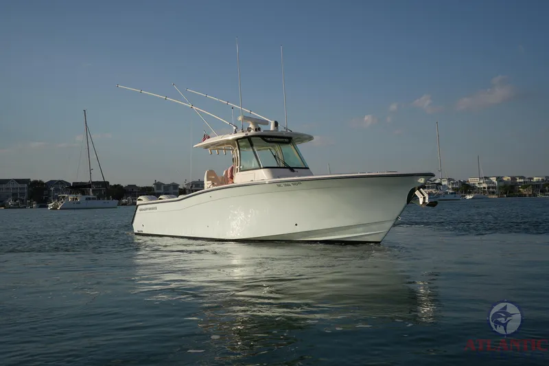 Slide: The Image of 2024 Grady-White Canyon 336 boat on calm water, with coastal background. - 13