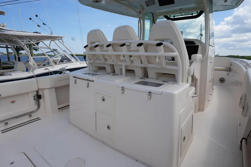 Slide: The Image of 2024 Grady-White Canyon 336 boat interior with seating and storage, docked under a blue sky. - 17