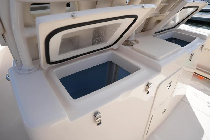 Slide: The Image of 2024 Grady-White Canyon 336 boat storage compartments with open lids, showcasing interior space. - 19
