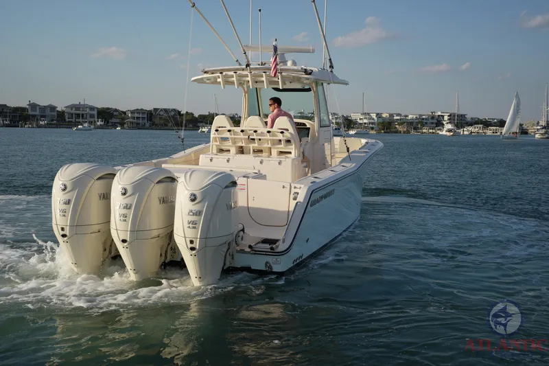 Slide: The Image of 2024 Grady-White Canyon 336 boat with triple Yamaha engines cruising on water. - 2