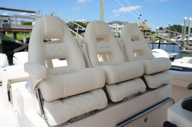 Slide: The Image of 2024 Grady-White Canyon 336 boat seats, luxurious white leather, docked marina background. - 20