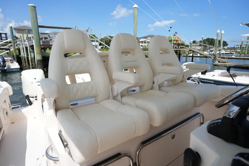 Slide: The Image of 2024 Grady-White Canyon 336 boat with luxurious white seating at a marina. - 21