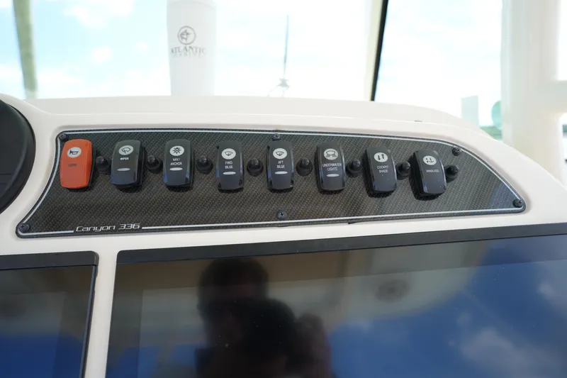 Slide: The Image of 2024 Grady-White Canyon 336 dashboard with control switches and display panel. - 27