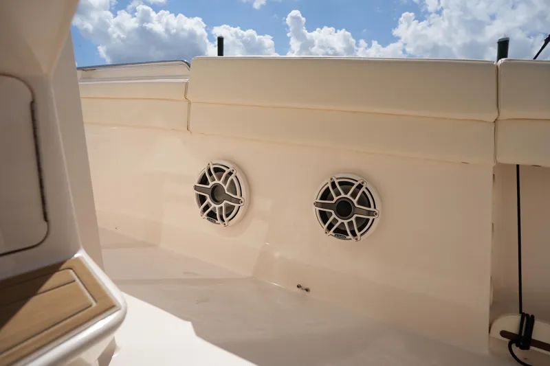 Slide: The Image of 2024 Grady-White Canyon 336 boat interior with speakers, under a blue sky. - 34