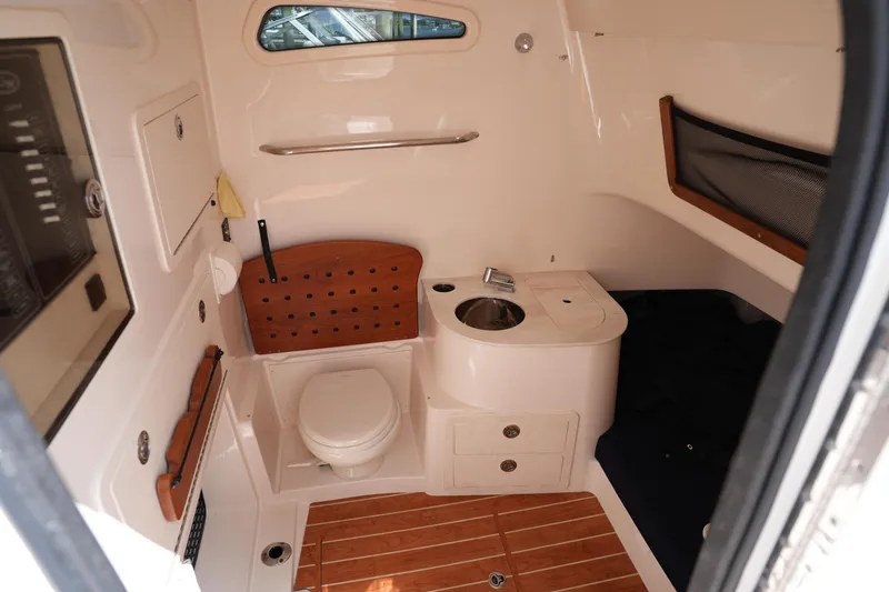 Slide: The Image of 2024 Grady-White Canyon 336 cabin interior with toilet, sink, and wooden flooring. - 35