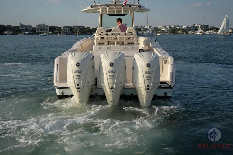 Slide: The Image of 2024 Grady-White Canyon 336 boat with triple outboard engines on water. - 4