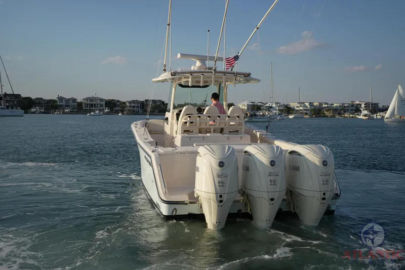 Slide: The Image of 2024 Grady-White Canyon 336 boat with triple Yamaha engines on calm water. - 5