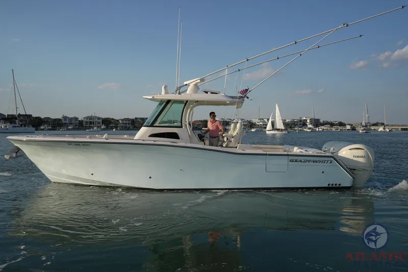 Slide: The Image of 2024 Grady-White Canyon 336 boat cruising in a scenic harbor setting. - 7