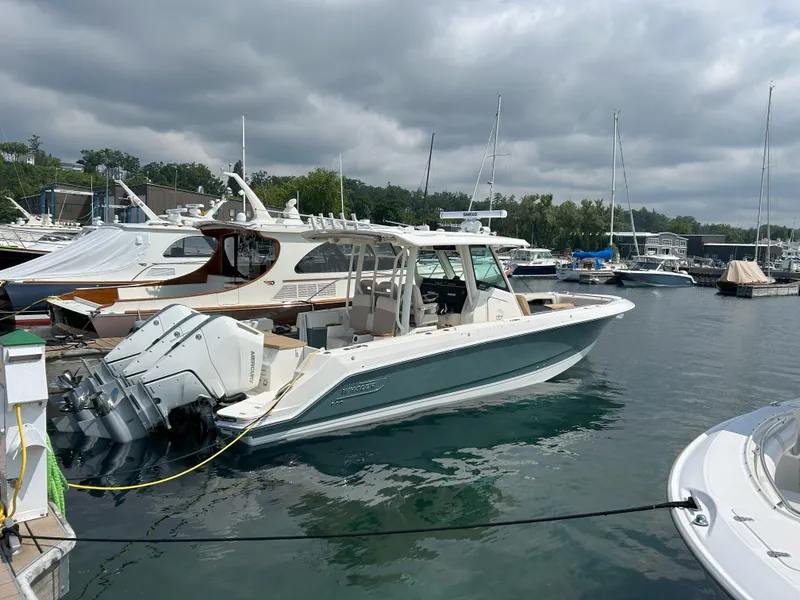 Slide: The Image of 2025 Boston Whaler 360 Outrage docked at marina under cloudy sky. - 1