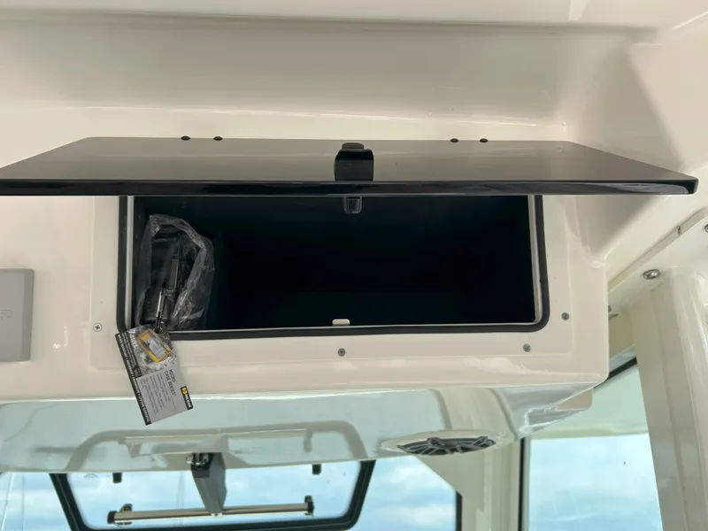 Slide: The Image of Open storage compartment on a 2025 Boston Whaler 360 Outrage boat interior. - 11