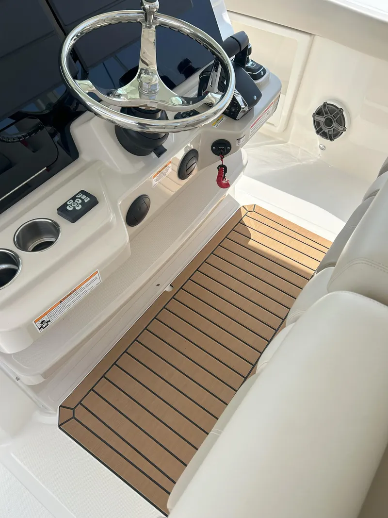 Slide: The Image of 2025 Boston Whaler 360 Outrage helm with steering wheel and control panel. - 16