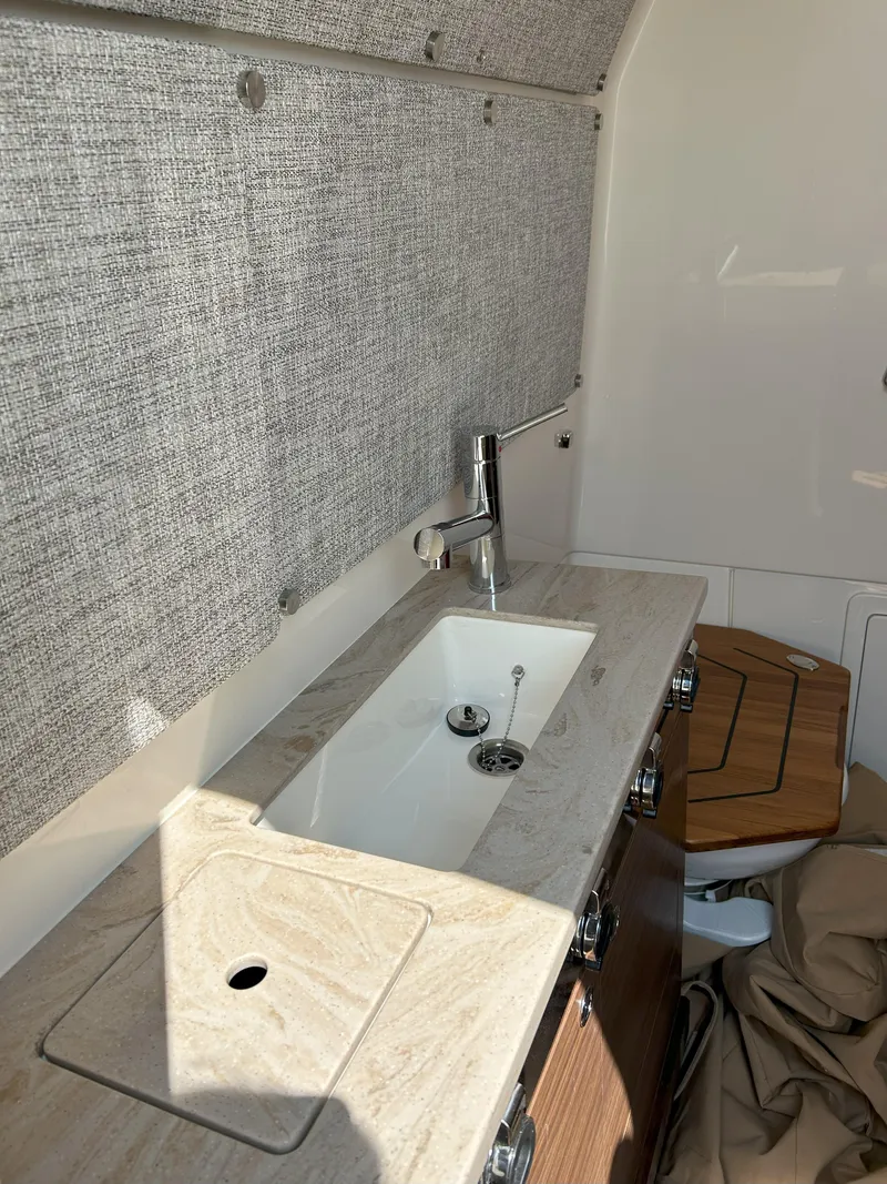 Slide: The Image of 2025 Boston Whaler 360 Outrage interior with modern sink and countertop design. - 22