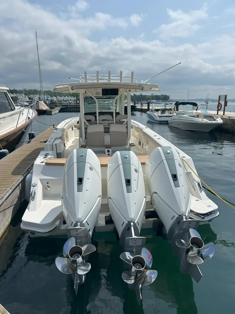 Slide: The Image of 2025 Boston Whaler 360 Outrage boat docked with triple outboard engines. - 3