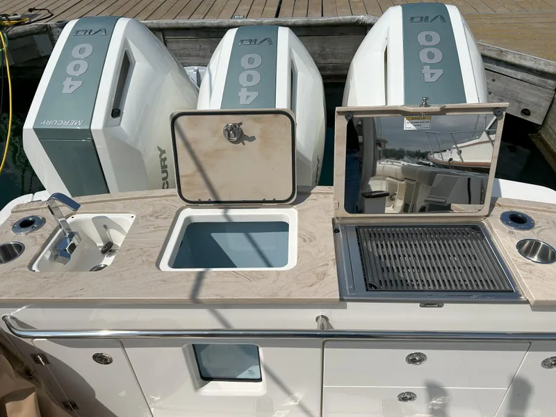 Slide: The Image of Boston Whaler 360 Outrage 2025 boat with triple Mercury 400 engines and onboard kitchen amenities. - 33