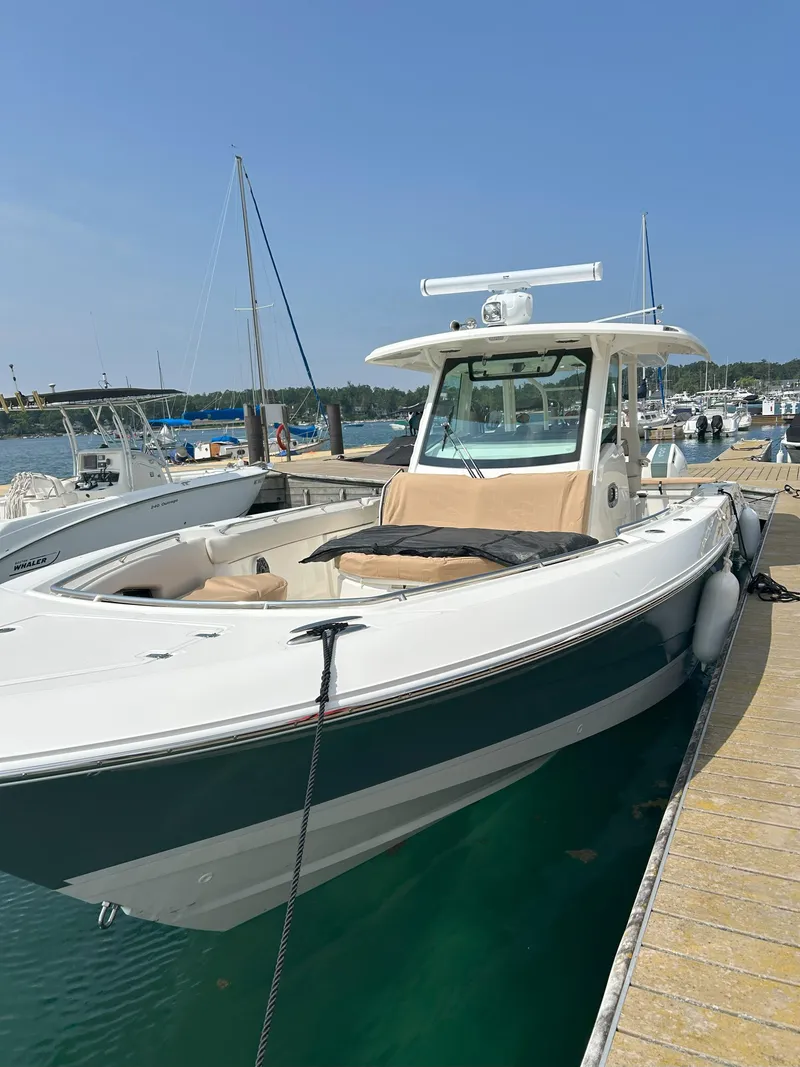 Slide: The Image of 2025 Boston Whaler 360 Outrage docked at marina under clear blue sky. - 6