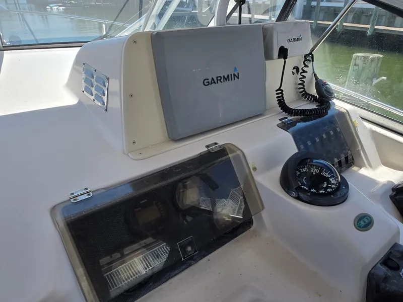 Slide: The Image of 2003 Grady-White Marlin 300 boat dashboard with Garmin navigation equipment and compass. - 12