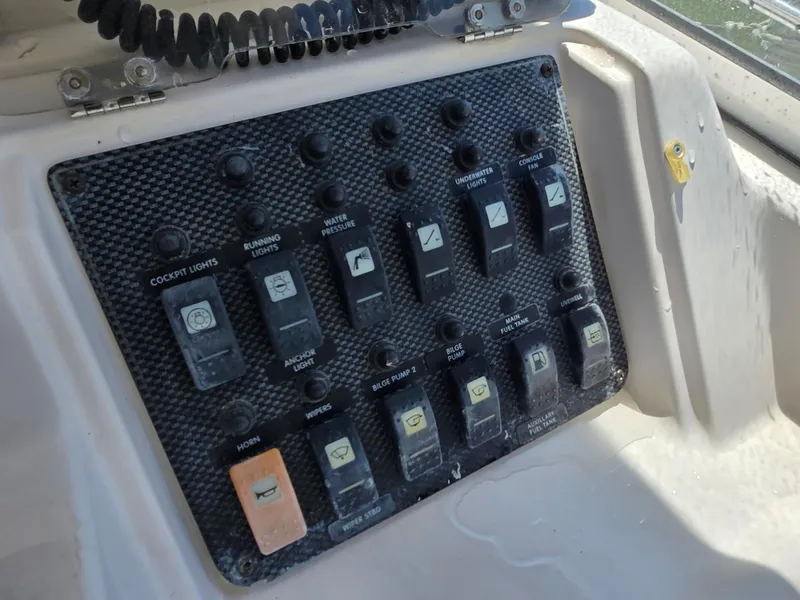 Slide: The Image of Control panel of a 2003 Grady-White Marlin 300 boat with various switches. - 14