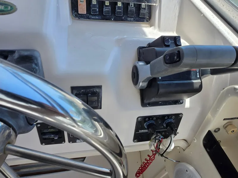 Slide: The Image of 2003 Grady-White Marlin 300 boat controls with steering wheel and throttle. - 16