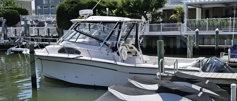 Slide: The Image of 2003 Grady-White Marlin 300 boat docked in a marina, featuring Yamaha engines. - 17