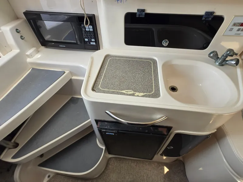 Slide: The Image of 2003 Grady-White Marlin 300 interior with kitchenette, sink, and microwave. - 7