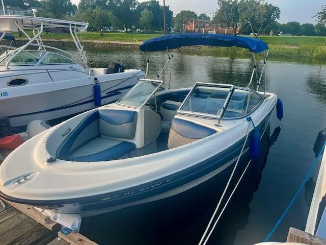 Slide: The Image of 2006 Bayliner 215 Classic boat docked with blue canopy and seating. - 2