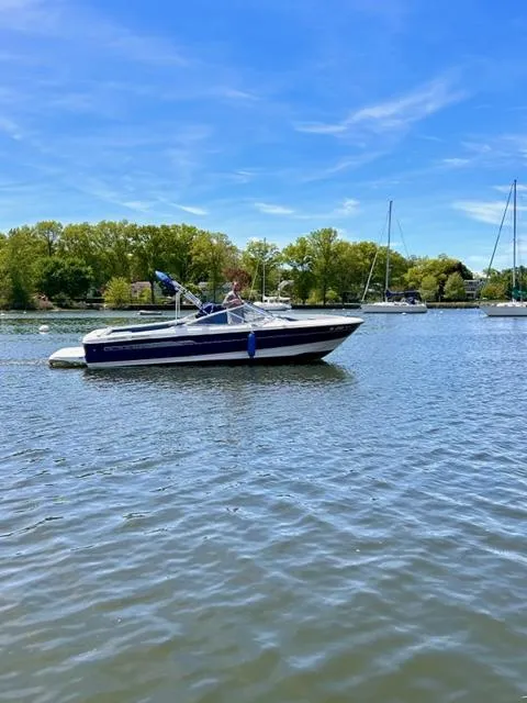 Slide: The Image of 2006 Bayliner 215 Classic boat on a calm lake with trees in the background. - 3