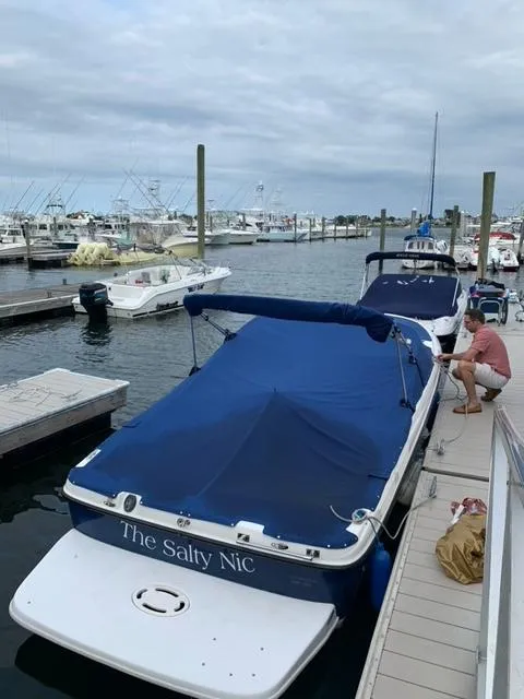 Slide: The Image of 2006 Bayliner 215 Classic boat docked with blue cover, marina background. - 8