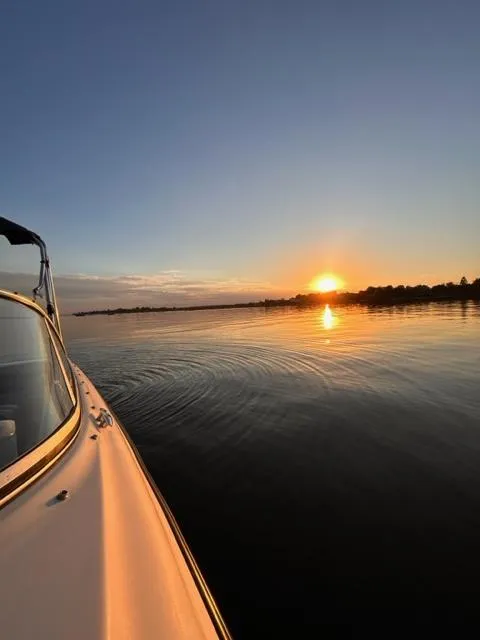 Slide: The Image of Bayliner 215 Classic boat on calm water at sunset, 2006 model. - 9