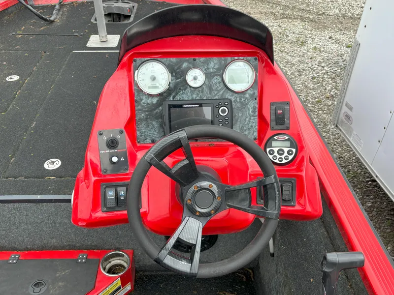 Slide: The Image of Red 2020 Raptor 160 Bass boat dashboard with steering wheel and gauges. - 6